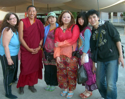 Photographer holding camera, Tibetan Buddhist Lama in robes, Chinese contingent, Tharlam Monastery Courtyard, Boudha, Kathmandu, Nepal by Wonderlane