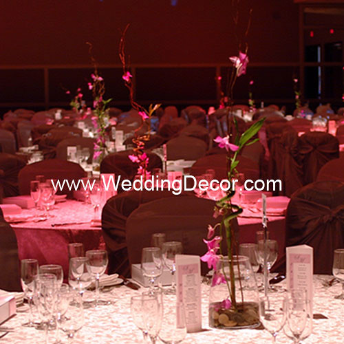 A wedding centerpiece with fuchsia orchids curly willow bamboo and rocks