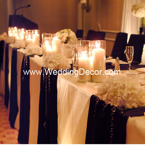 Head table decorations for a wedding reception in black and ivory with 