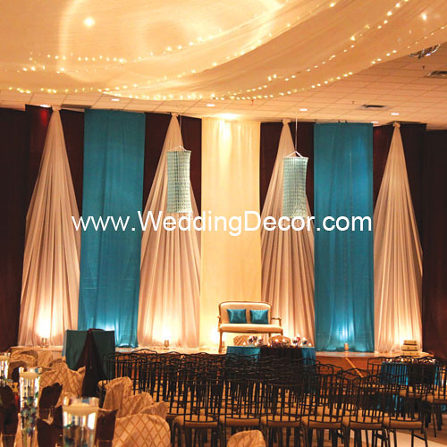 A turquoise and ivory wedding backdrop with matching cake table and fabric