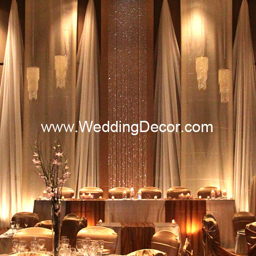 A champagne and ivory wedding backdrop with matching head table and cake 