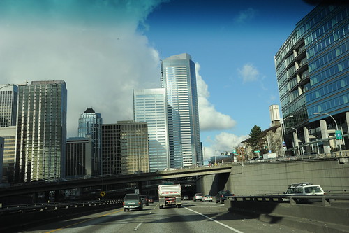 Cloud cover opens, the silver steel jet city, from Highway 5, skyscrapers, steel, concrete, Seattle, Washington, USA by Wonderlane