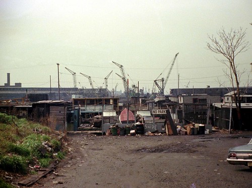 Which do you prefer? Color or B&W version? Industrial ruins and crane graveyard at the end of Greene St toward the Morris Canal and the Statue of Liberty. Jersey City. March 1975