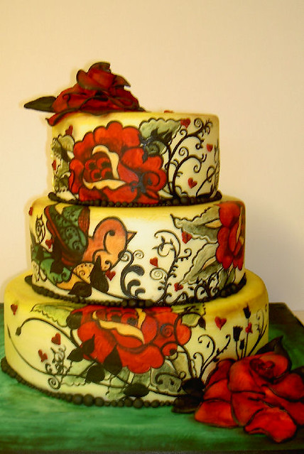 An Alternative Wedding Cake with an all over painted design and 2 large red