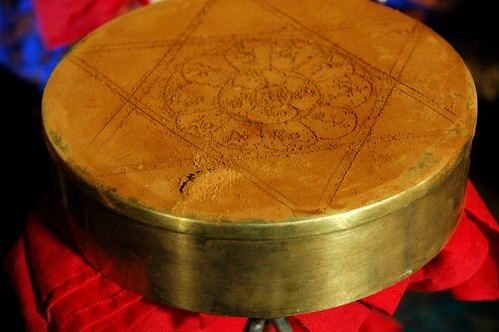 Vajrayogini Empowerment Torma with sindhura powder, with six pointed star and seed syllable letters on lotus shaped design, for diety offering on metal mandala over red fabric, shrine, Tharlam Monastery, Boudha, Kathmandu, Nepal by Wonderlane