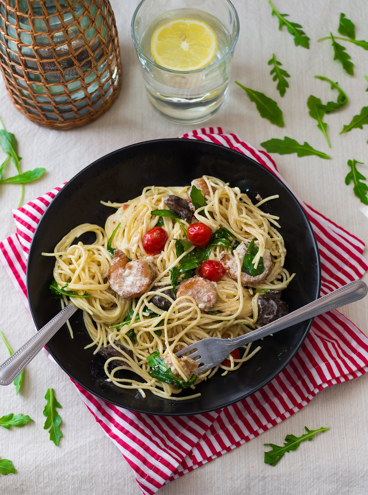 food scene with pasta topped with tomatoes mushroom and shrimp