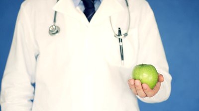 stock-footage-male-doctor-holding-green-apple-on-blue-background