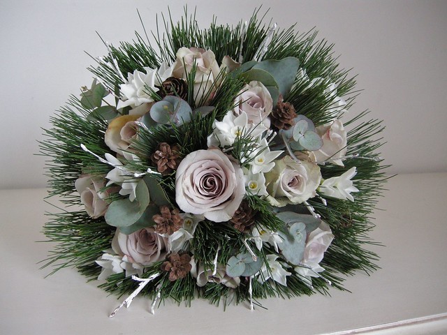 Vintage winter wedding bouquet of lilac roses pine cones and paperwhites 