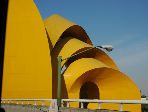 Sun yellow sculpture, metal arches, green street lamp, as seen from the highway, central Guadalajara, Jalisco, Mexico by Wonderlane