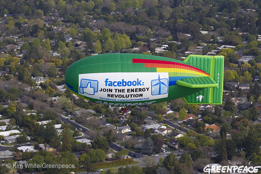 f banners facebook upload images. The Greenpeace Airship A.E. Bates flies overhead with a banner reading 