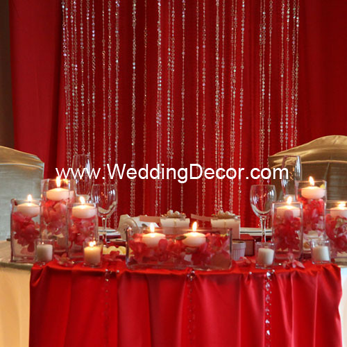 Head table decorations for a wedding reception in red and gold with floatin