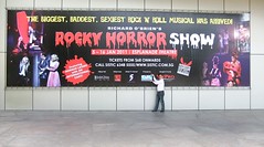Tim Lawson in front of Rocky Horror Show billboard in Singapore
