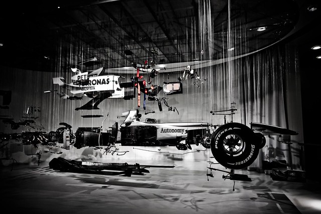 An old mercedes formula 1 car dismembered and suspended from the ceiling at