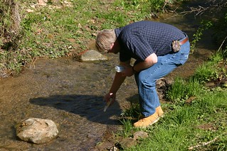 Rick Handshoe using a conductivity meter in a creek.
