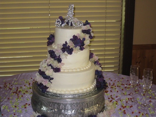 3 tier round wedding cake with fresh flowers for accents cascading from the