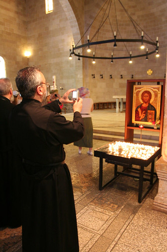 priest taking a digital photo of Jesus