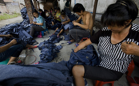 新塘鎮久裕村的打工者在簡易的大棚下加工牛仔褲。這裡隨處可見手工處理牛仔服裝的工人。從早到晚，都有工人把一堆堆牛仔服裝裝上貨車。