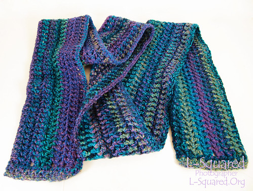 Scarf striped in shades of purple, blue, teal and green.