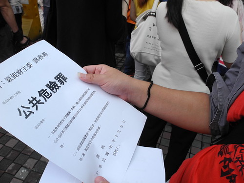 民眾拿著控訴蔡春鴻觸犯公共危險罪的紙張，貼在原能會門前。