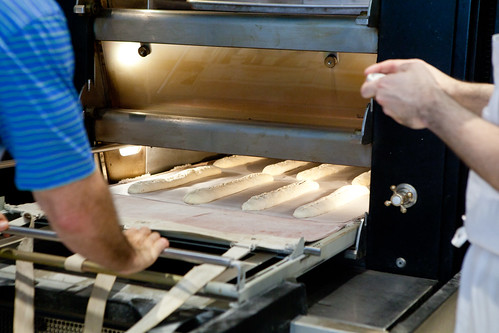 Pushing the rack of baguettes into the oven
