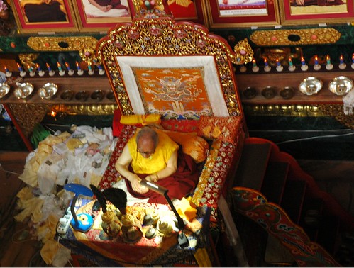 His Holiness Jigdal Dagchen Sakya Rinpoche on his throne with traditional Buddhist impliments, staircase, and a pile of katags mixed with offerings, Sakya Lamdre, Tharlam Monastery of Tibetan Buddhism, Boudha, Kathmandu, Nepal by Wonderlane