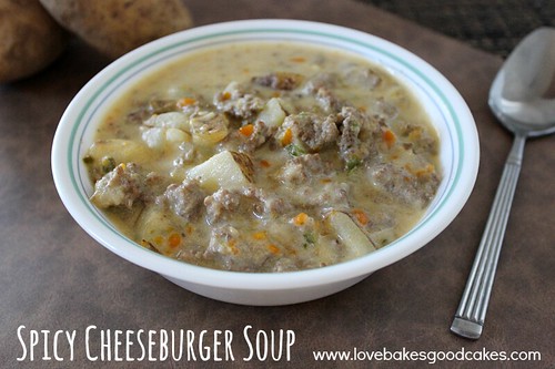 Spicy Cheeseburger Soup in white bowl with spoon.