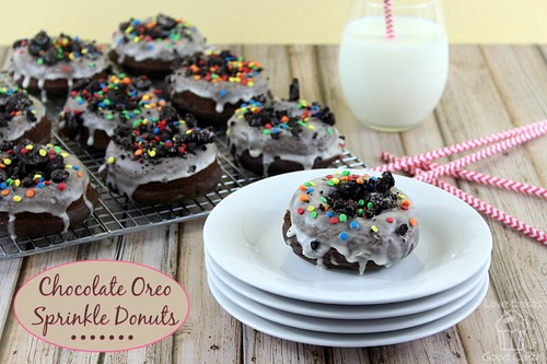 Chocolate Oreo Sprinkle Donuts on cooling rack with one donut on a stack of plates with a glass of milk.
