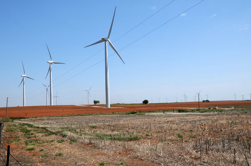 A tractor tills the soil among wind turbines in Oklahoma on August 13, 2009. USDA photo by Alice Welch.