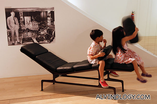 Two kids playing on a Eames designed lounge chair 