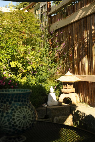 Private and relaxing view, white Buddha statue, Japanese lantern, against a bamboo fence, glass lamp, mesh patio table, umbrella shadow, sunlight, block walls, A Garden for the Buddha, Seattle, Washington, USA by Wonderlane