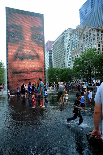 Woman's face fountain, Waterfall Fountains at Millenium Park, crowd in the waterfall, kids and parents splashing and playing, shallow pool, hot bright day, art and architecture, Chicago, Illinois, USA by Wonderlane