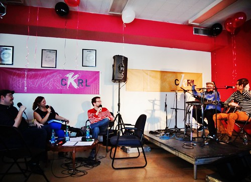[ Photo 2013 du studio intérieur du Radiothon : petite scène, chaises devant, haut-parleur, bannière CKRL, musiciens.]