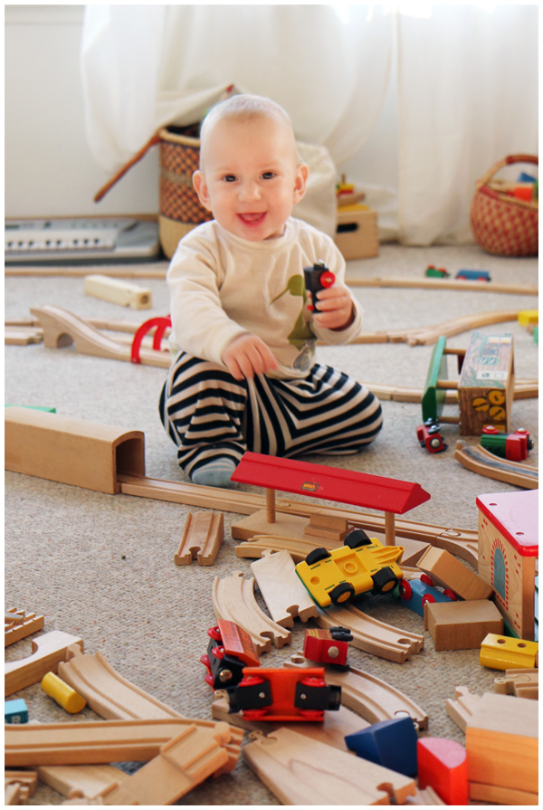 Baby playing with wooden trains