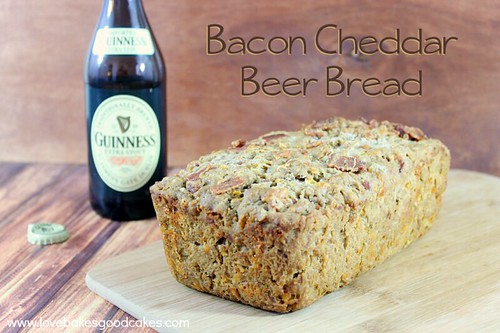 Bacon Cheddar Beer Bread loaf on a cutting board with a bottle of Guinness.