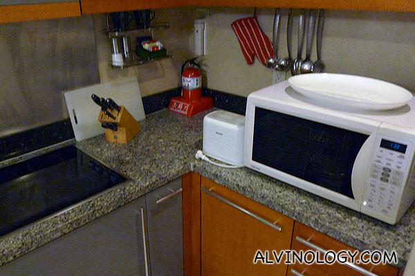 There is a microwave, stove, and full set of cookware and utensils 