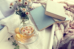 Cup of tea, macaroons, chrysanthemum flowers and books