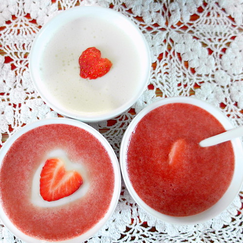 Caramelized Honey and Lavender Panna Cotta in ramekins with slices of fresh strawberries, cut in heart shapes, on top.