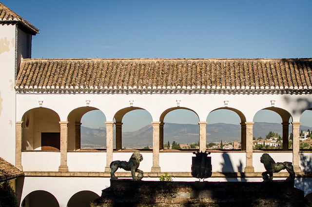 The arched walkway over the Generalife Palace offers breathtaking views of the Sierra Nevada mountains and the city of Granada.