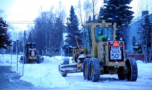 Stay back 50ft, snow removal with snow grators, 6 wheeled tractors plowing snow from city streets, cloudy day, mid-winter, Anchorage, Alaska, USA by Wonderlane