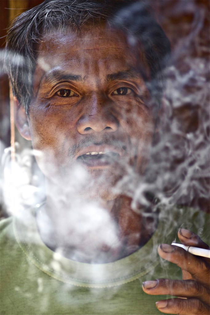 A Hmong Gentleman Puffs On His Cigarette