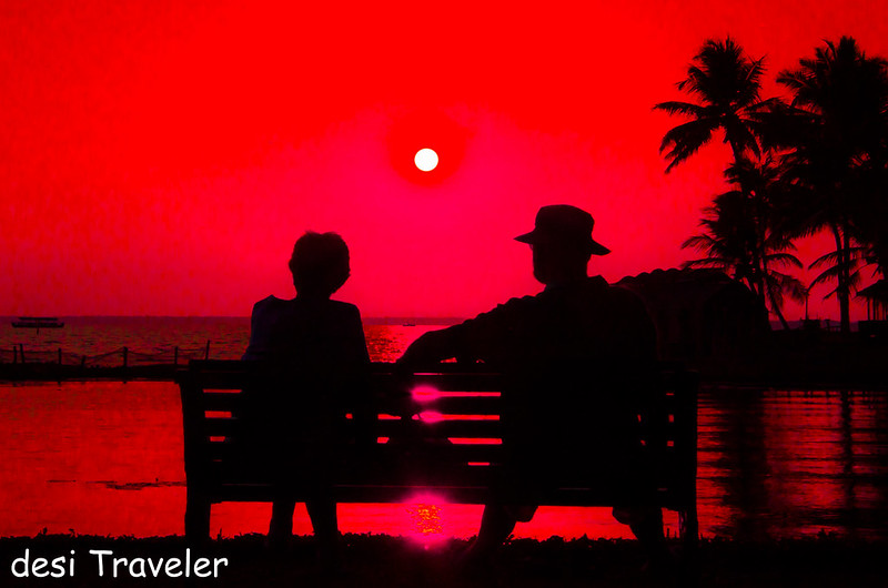 couple on bench enjoying sunset lake vembanad kumarakom lake resort