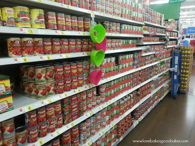 Grocery store isle with Hunts canned tomatoes on the shelves.