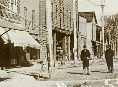 people usa signs man men history fence buildings walking advertising awning clothing restaurants indiana streetscene lynn departmentstore porch shops pedestrians hotels storefronts grocery businesses randolphcounty realphoto hoosierrecollections