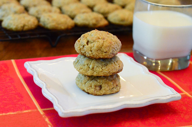 A stack of Oatmeal Coconut Date Cookies on a plate next to a glass of milk.