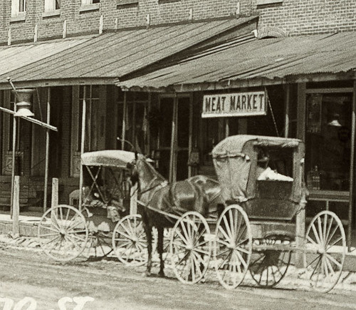 horses people woman usa signs man men history fence buildings walking advertising awning hardware clothing women mail postoffice indiana streetscene fremont transportation drugs shops pedestrians storefronts buggy buggies businesses jeweler realphoto steubencounty hoosierrecollections