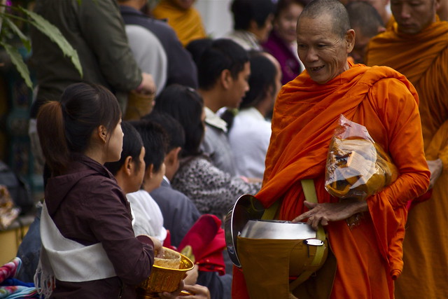 A Senior Monk Collecting Alms In Luang Prabang