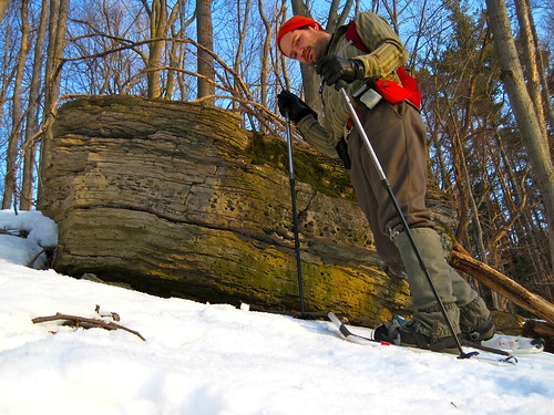 man snowshoeing with gaiters looking down at camera