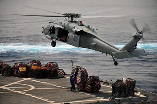 USNS Tippecanoe merchant marine prepares to attach cargo to Sea Hawk.