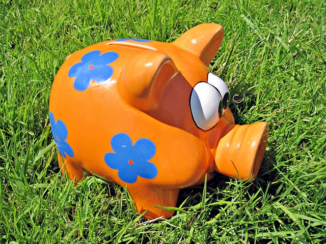 Orange piggy bank on grass