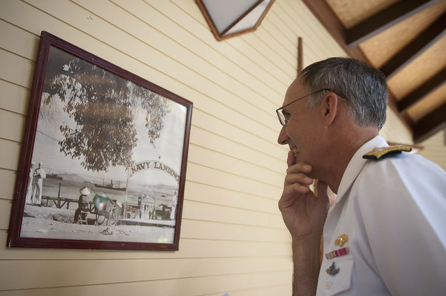 U.S. Navy admiral looks at a photograph of Noumea, New Caledonia, during World War II